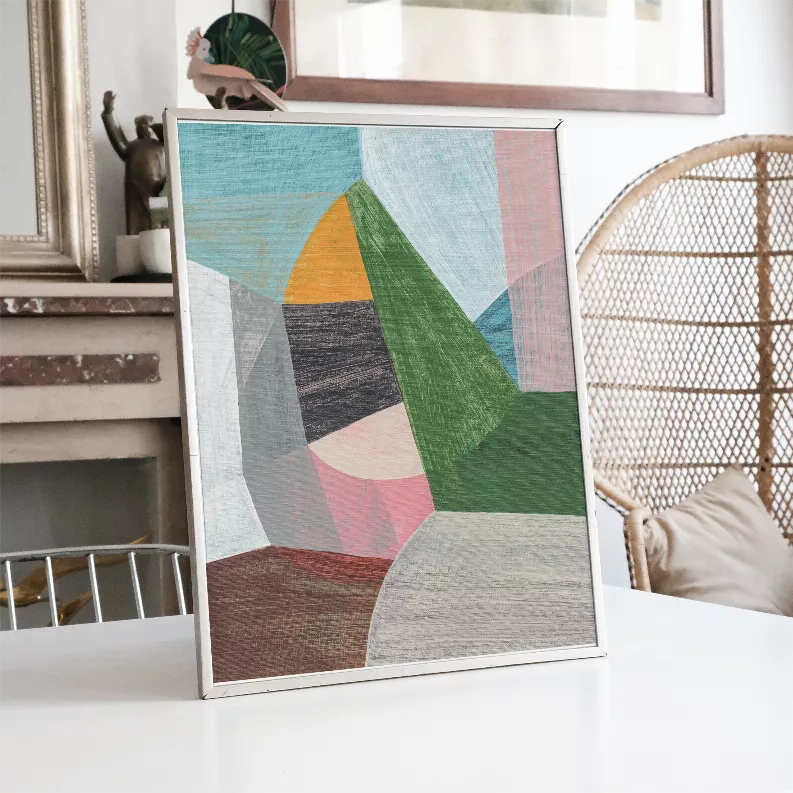 Framed abstract wall art print with teal, green, pink, and brown geometric blocks.
