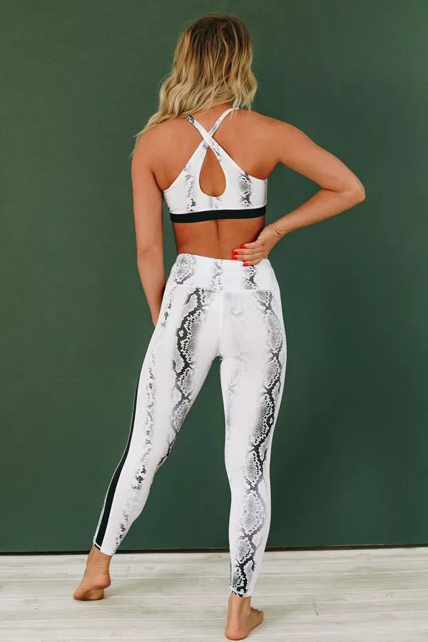 Snake-patterned active set: back view with X-strap sports bra and matching leggings, gray trim