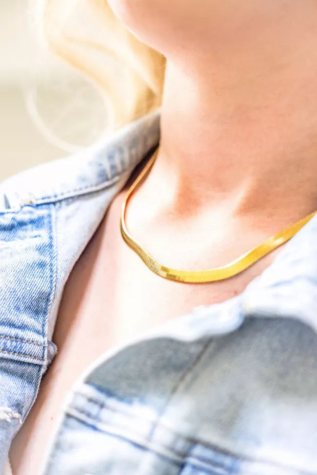 Worn gold herringbone necklace with slim neckline chain and tiny bead links