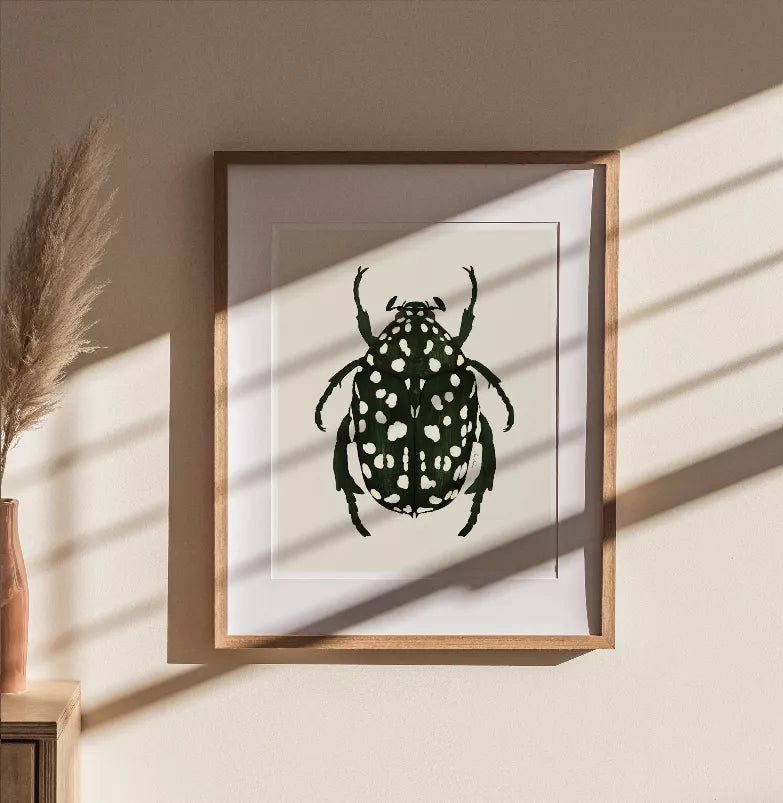 Square framed beetle artwork with dark green insect and white spots, wood frame.