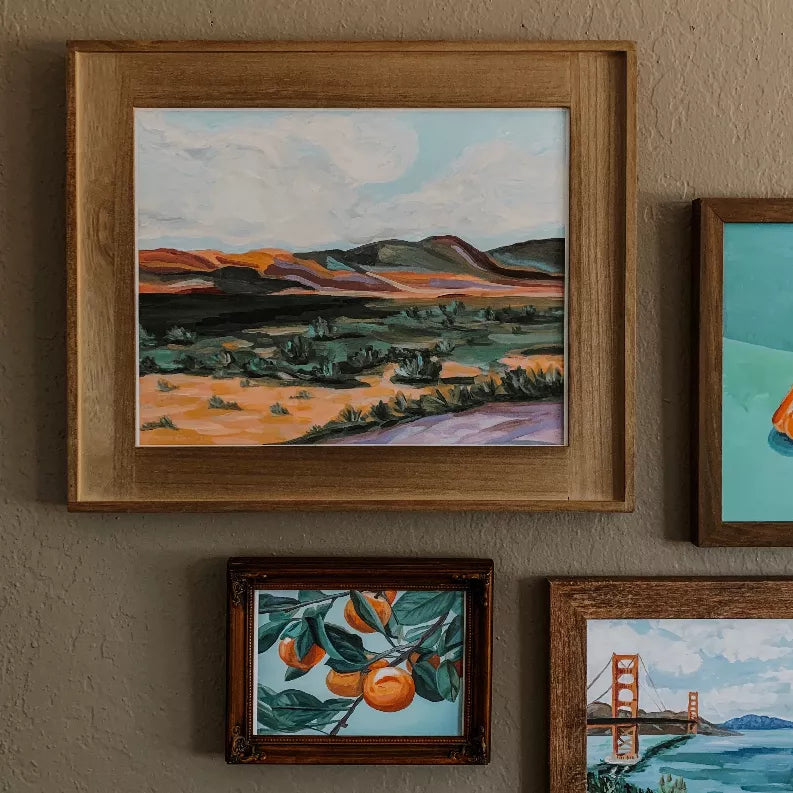 Wooden-framed landscape wall print with desert path and mountain hills