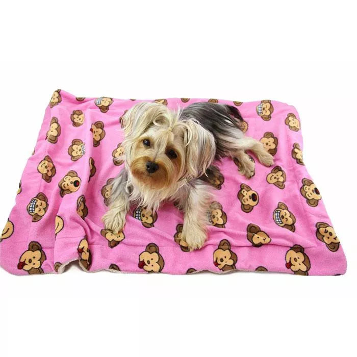 Pink ultra-plush blanket with repeating cartoon monkey faces