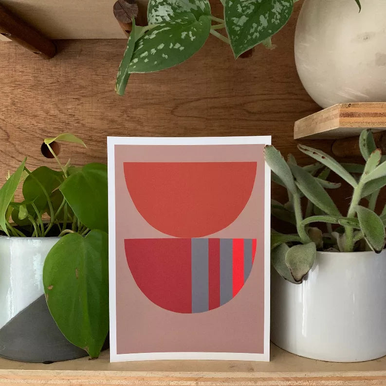 Framed abstract art print with stacked red semicircles and gray vertical stripes on a pale mat