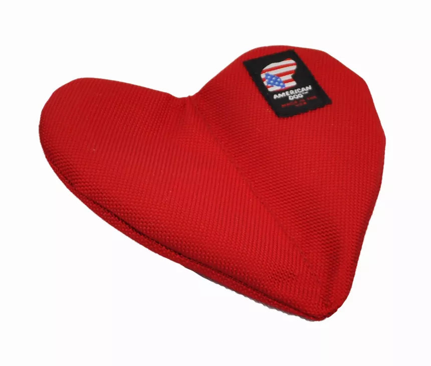 Red heart-shaped plush dog toy, textured fabric with black logo patch