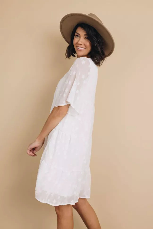 Light blue babydoll dress with flutter sleeves and tiered skirt, three-quarter side view
