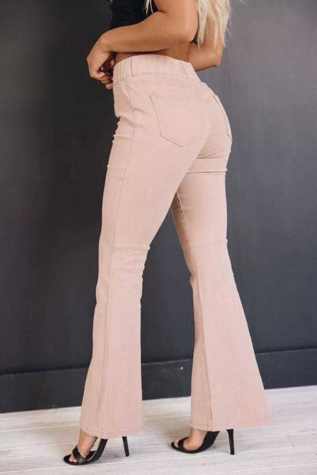 Light beige high-rise flare jeans, side view, wide bootcut legs and belt loops