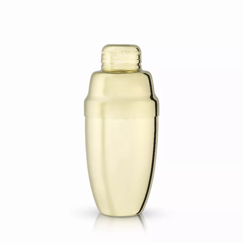 Gold cocktail shaker with rounded metal body and capped lid