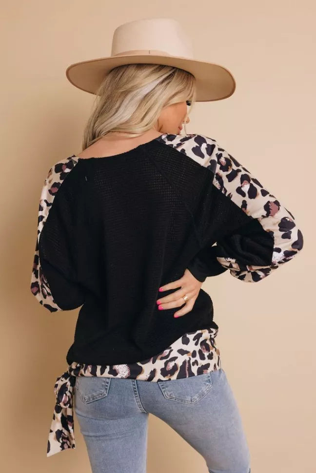 Black long-sleeve top with leopard print back yoke and tied waist hem