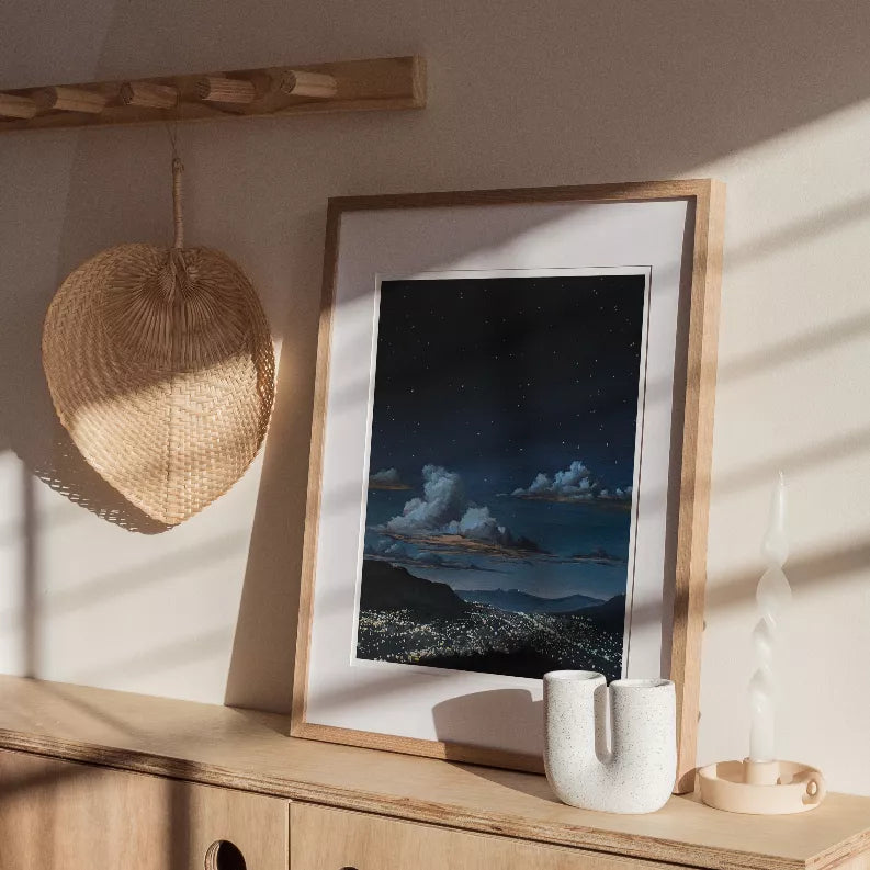 Framed night sky landscape print with clouds and city lights, wood frame.