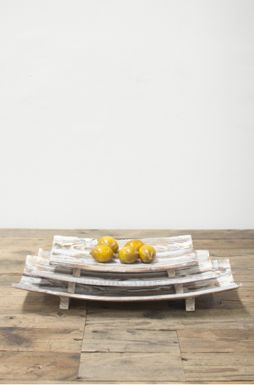 Set of three rectangular curved wooden bowls, stacked with yellow fruit