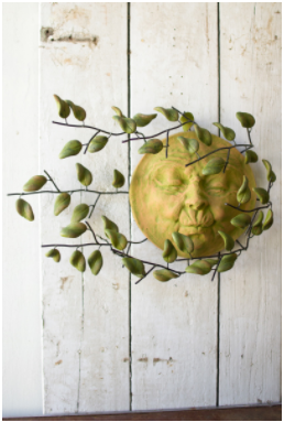 Green clay sun face wall hanging with windblown leaf accents, circular design