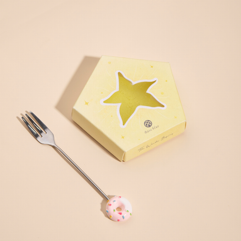 Yellow star soap bar on a cardboard box next to a fork