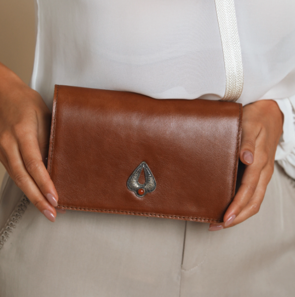 Brown leather flap belt bag with triangular metal logo