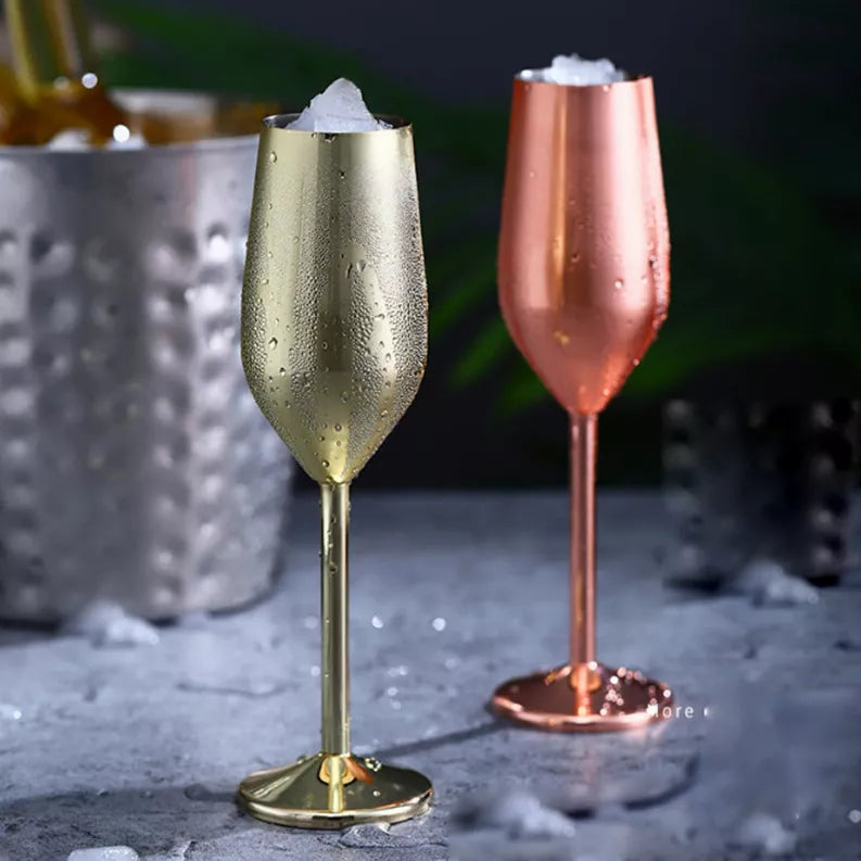 Gold and rose-gold champagne cocktail glasses with stem bases and water droplets