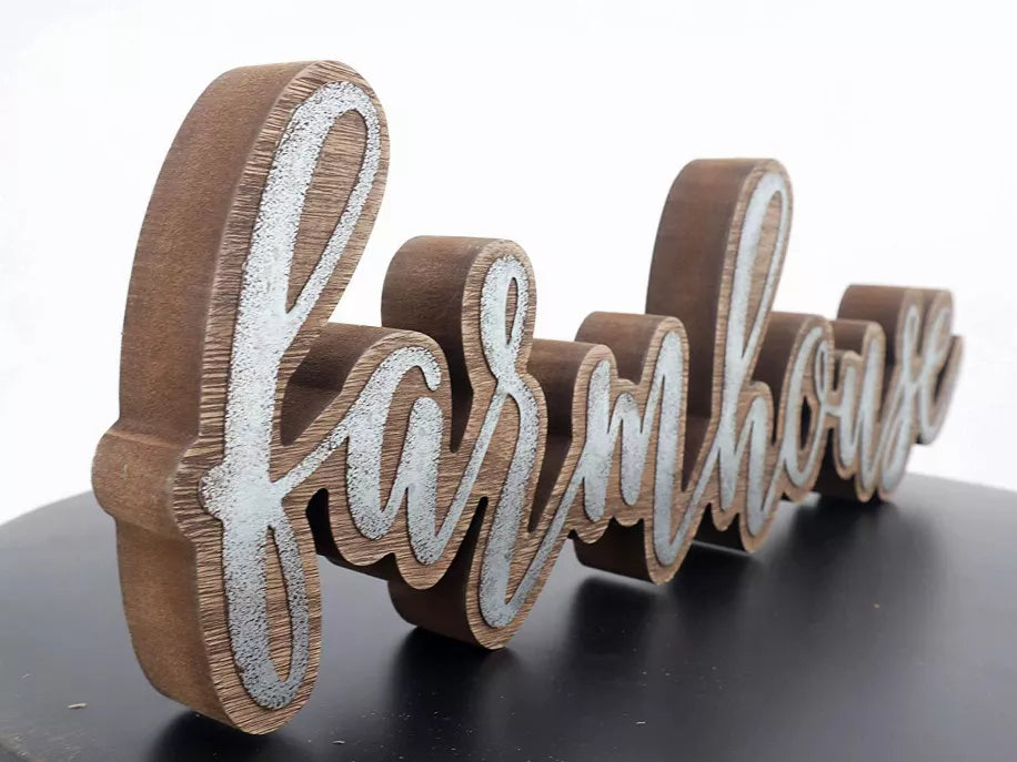 Close-up farmhouse word sign: tall brown script letters with white distressed centers