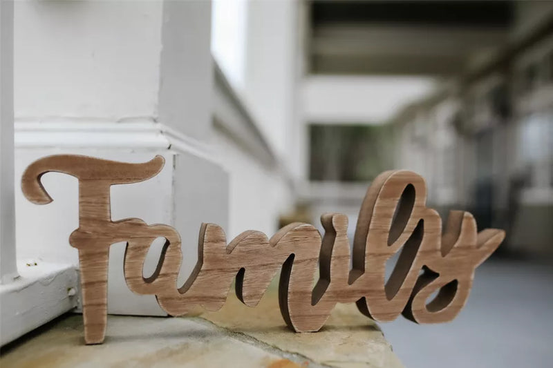 Rustic wooden tabletop sign reading 'Family', freestanding on a surface