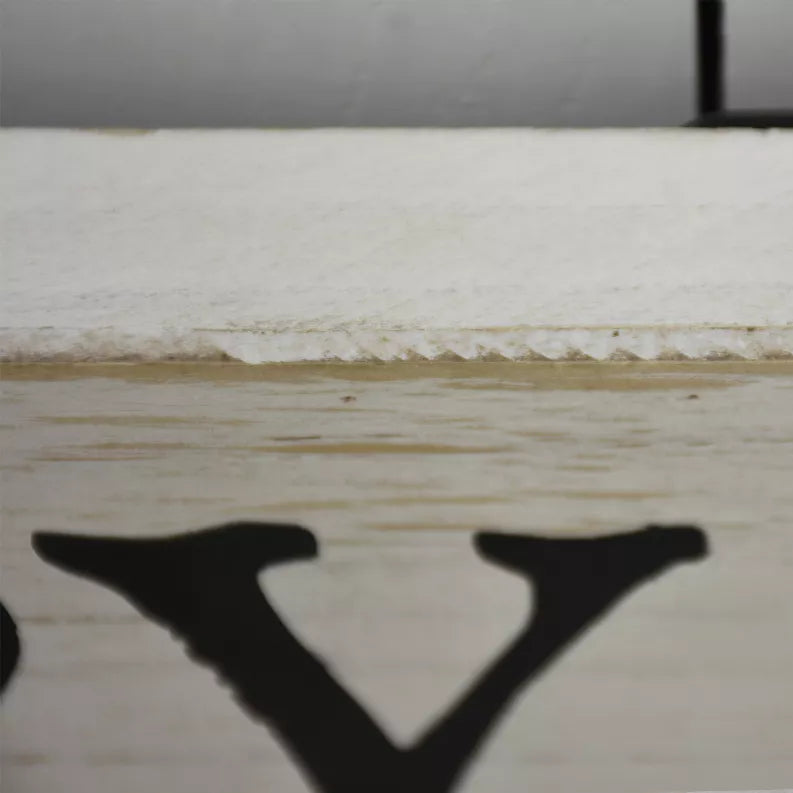 Whitewashed wood pantry sign close-up showing bold black letter 'V'