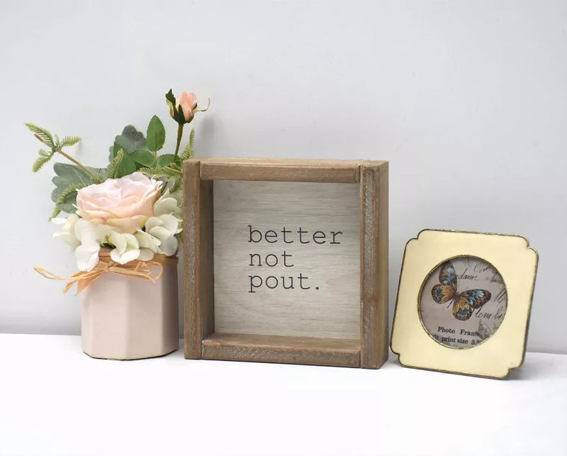 Square wood framed wall sign with "better not pout." lettering on light panel