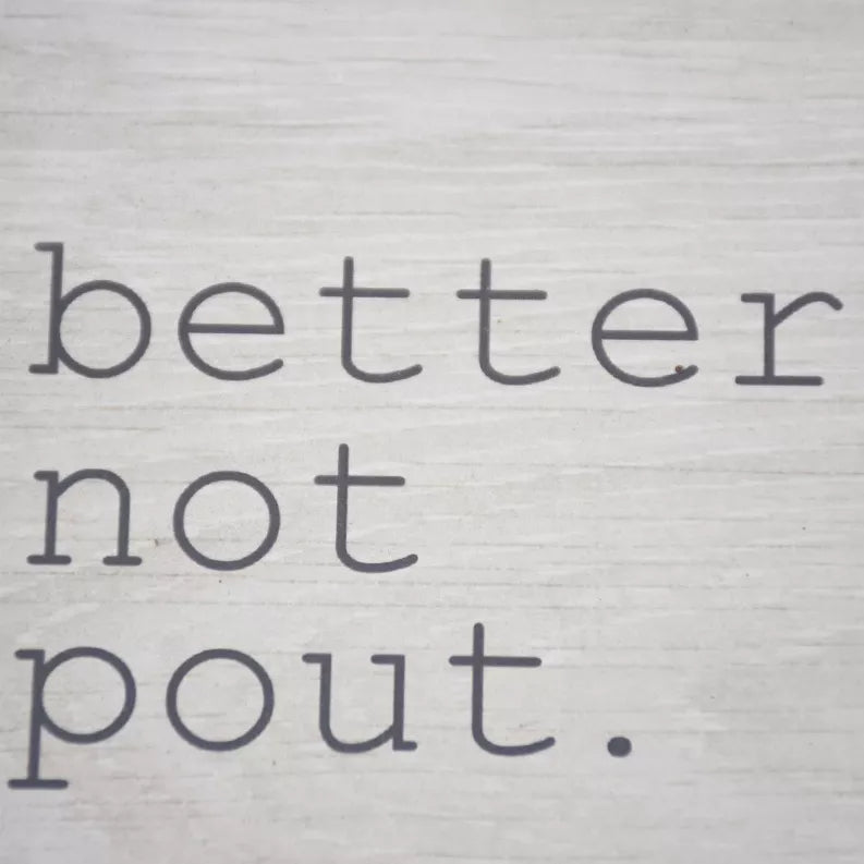 Close-up of "better not pout." lettering on a light wood wall sign panel