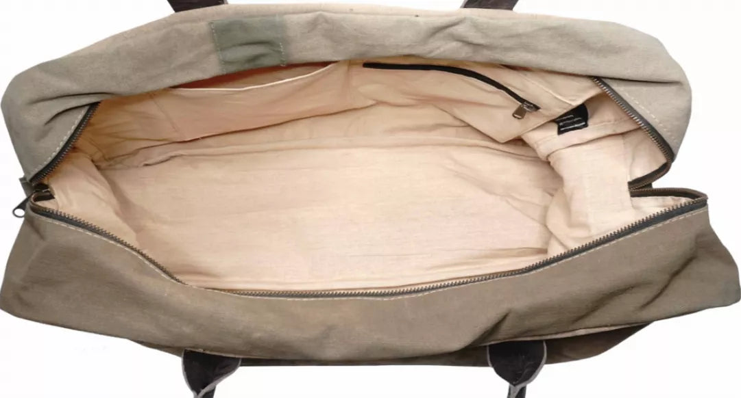 Open canvas duffel bag showing light interior lining and inner zip pocket