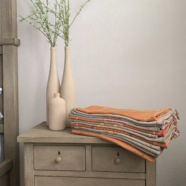 Folded striped woven fabric in gray, rust, and tan