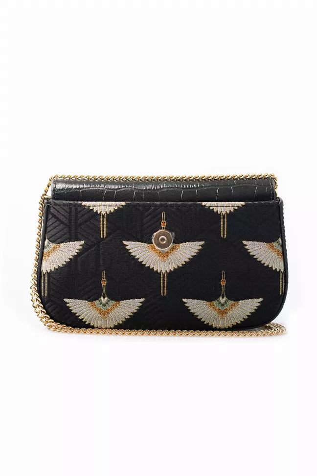 Black chain bag with gold wing embroidery, tassel accents, and top flap