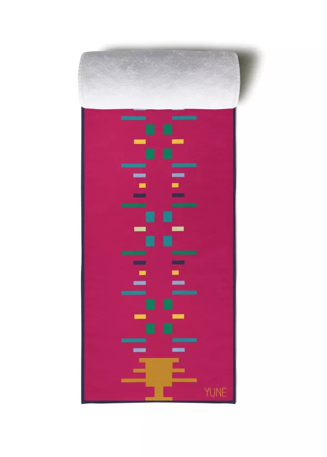 Pink yoga towel with teal and yellow geometric lines, 'YUNE' logo at bottom right