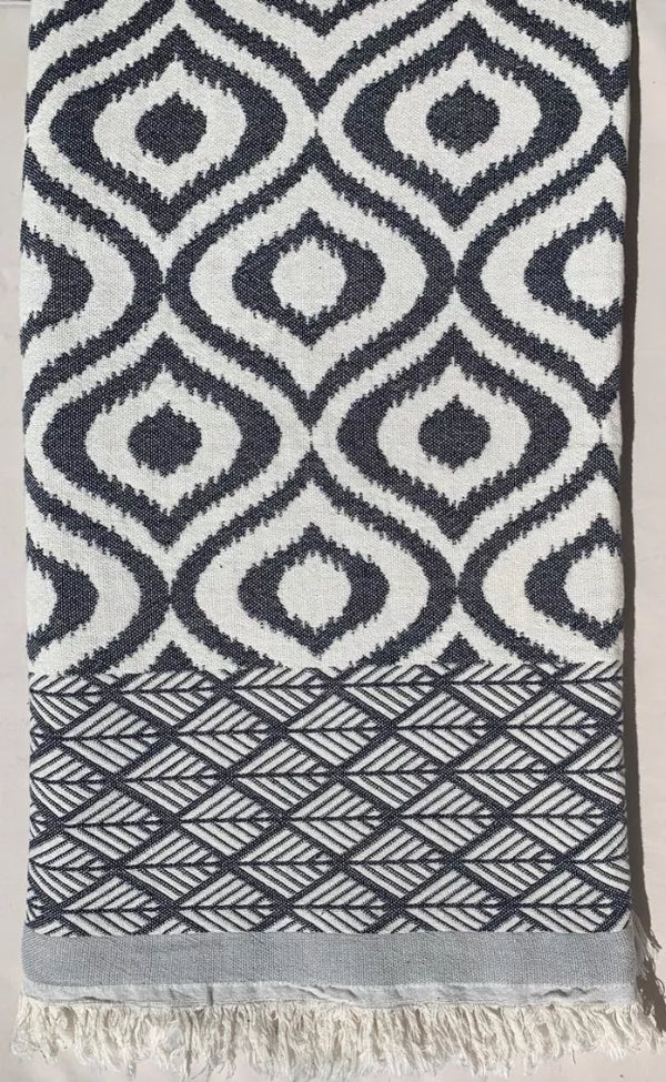 Black and white ikat patterned Turkish throw with fringed edges and geometric border