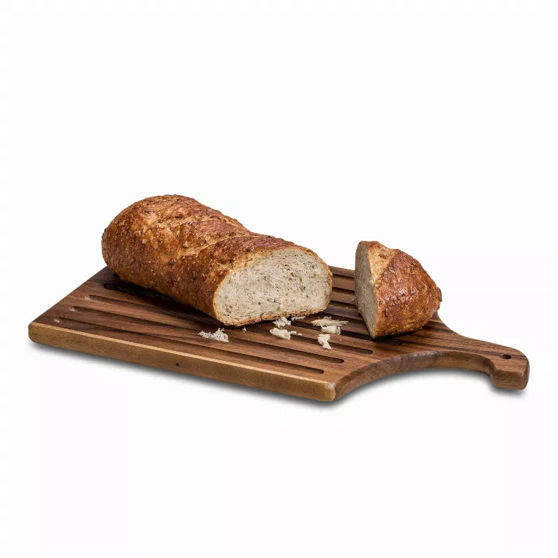 Wood slotted bread board with curved handle and sliced loaf pieces