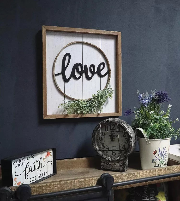 Framed wall sign with circular hoop 'love' and green foliage