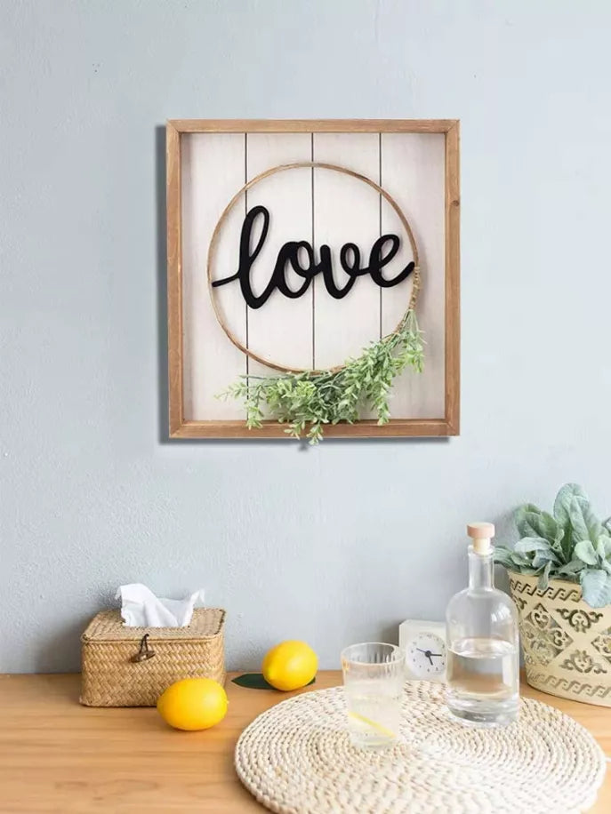 Small framed wall sign with circular hoop 'love' and green foliage