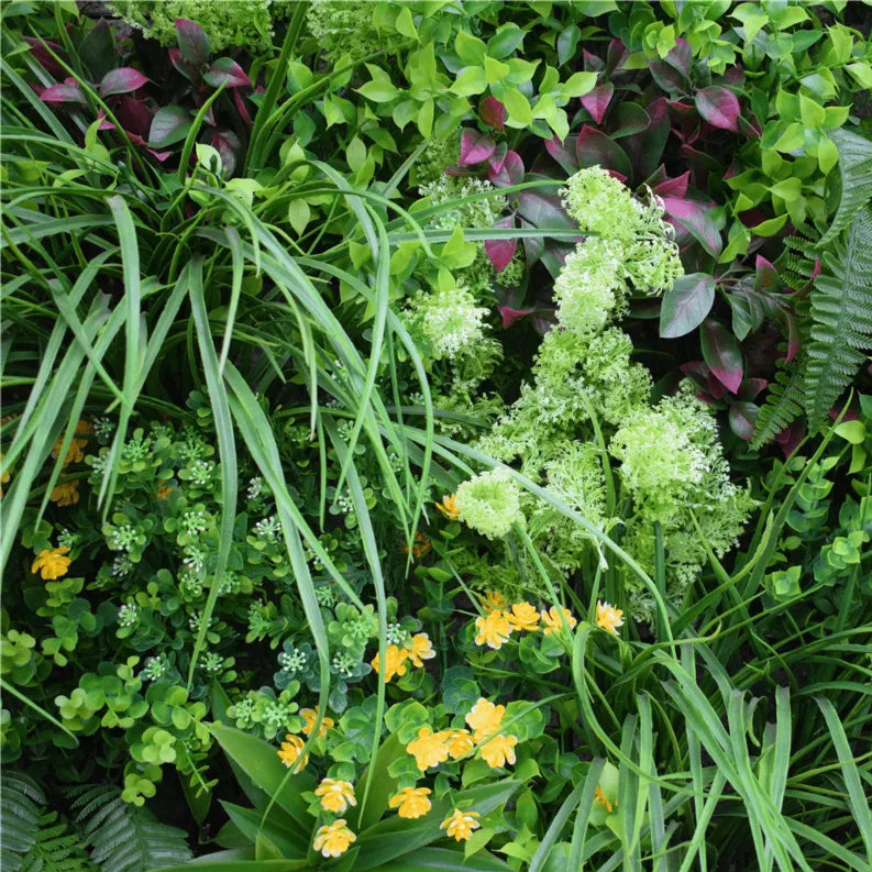 Artificial vertical garden wall panel with mixed green foliage, ferns, and small yellow flowers