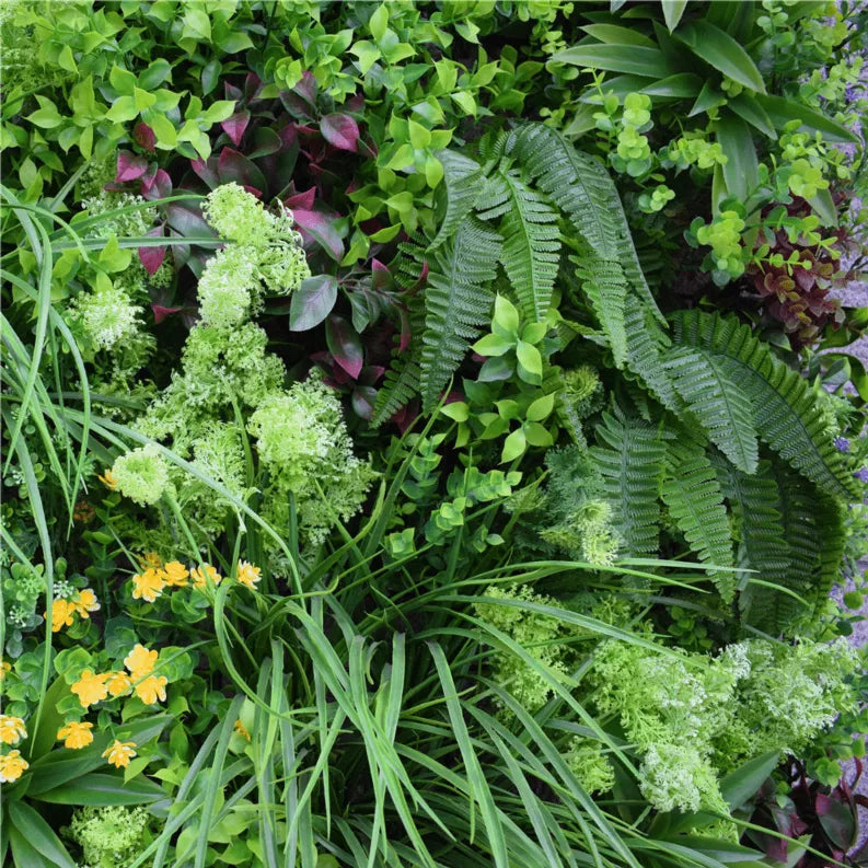 Artificial vertical garden wall panel with green grasses, ferns, and pale purple leaf clusters
