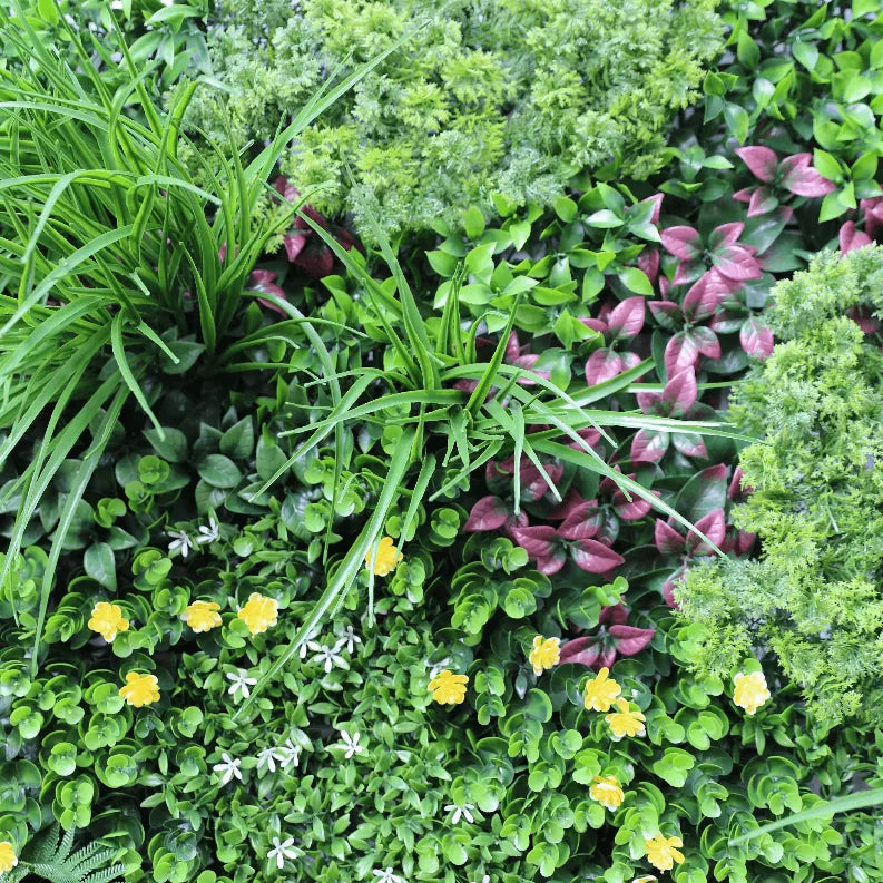 Artificial vertical garden wall panel close-up with green groundcover, purple leaves, and yellow blooms