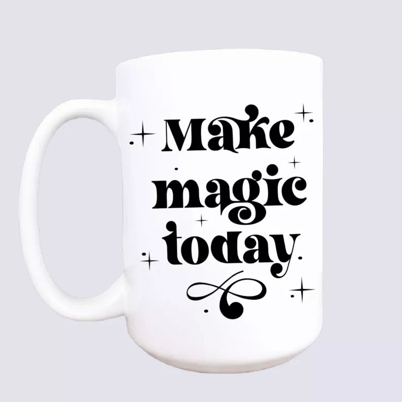 White ceramic coffee mug with black "Make magic today" text and sparkle accents