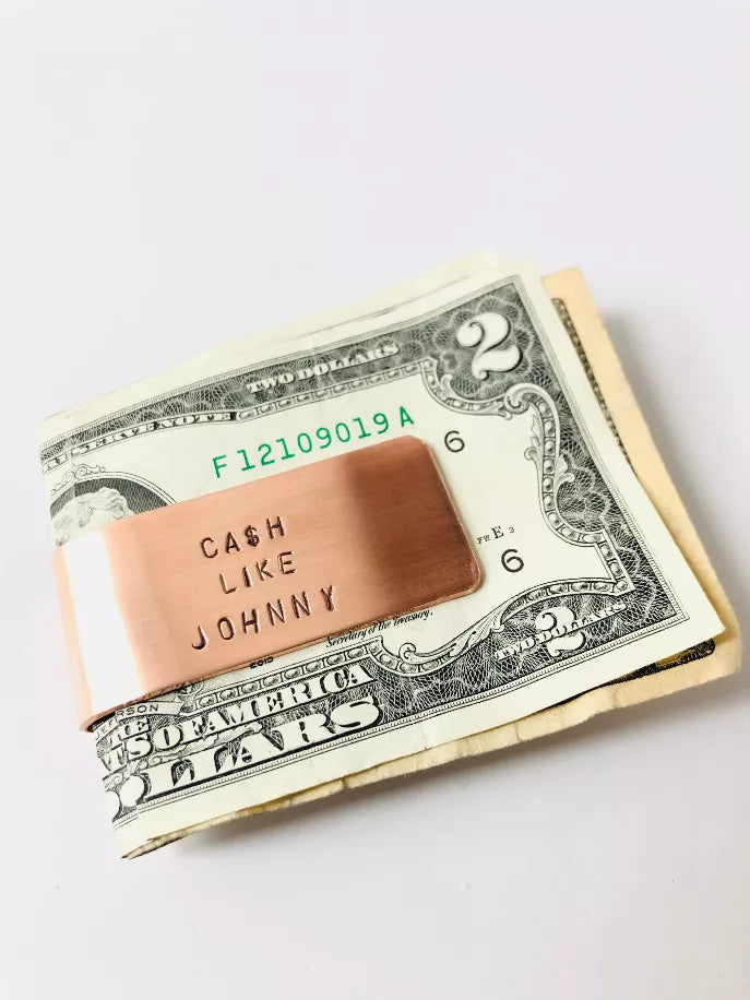 Copper money clip with “Cash Like Johnny” engraving over US $ bills