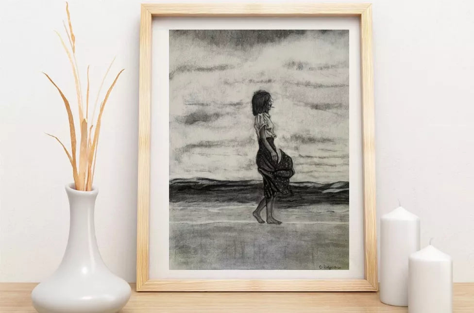 Framed monochrome art print of a standing woman silhouette by an ocean horizon.