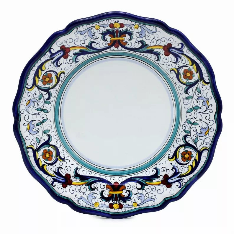 Decorative blue dinner plate with scalloped edge, turquoise ring, and colorful floral scroll border