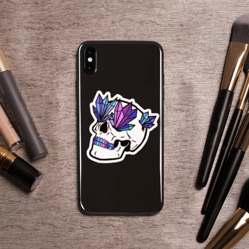 Crystal Skull 2.0 sticker on black phone, white skull with purple and blue crystals.