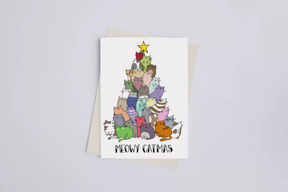Greeting card with colorful illustrated cats and gold star, set on kraft envelope