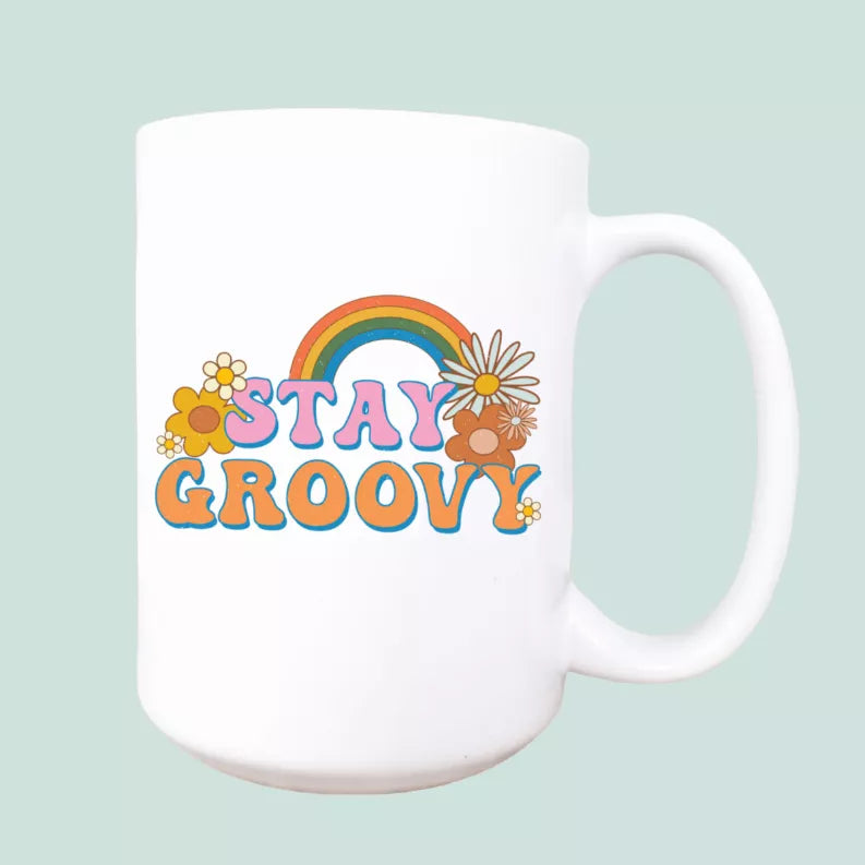 Ceramic coffee mug with colorful rainbow “Stay Groovy” graphic and white handle, 15oz