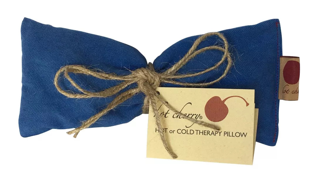 Blue denim eye pillow with bow and cream tag labeled hot or cold therapy pillow.