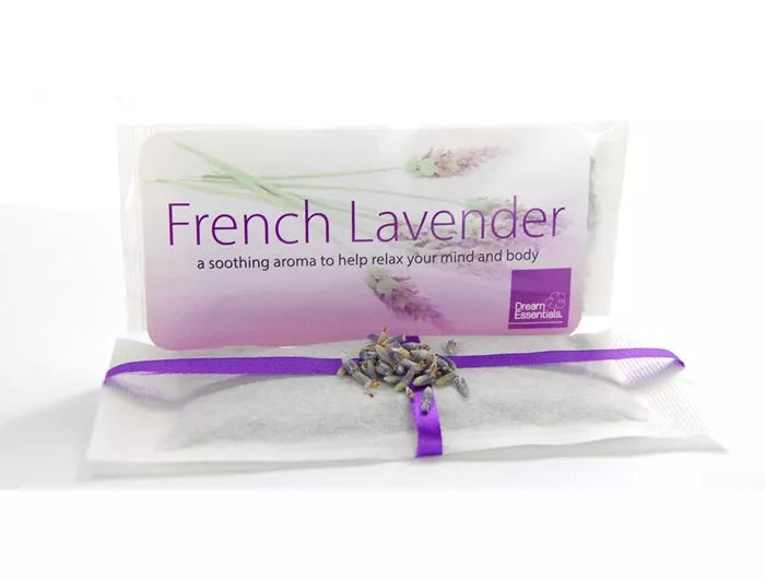 Lavender herb sachet in white pouch tied with purple ribbon, with dried lavender sprigs