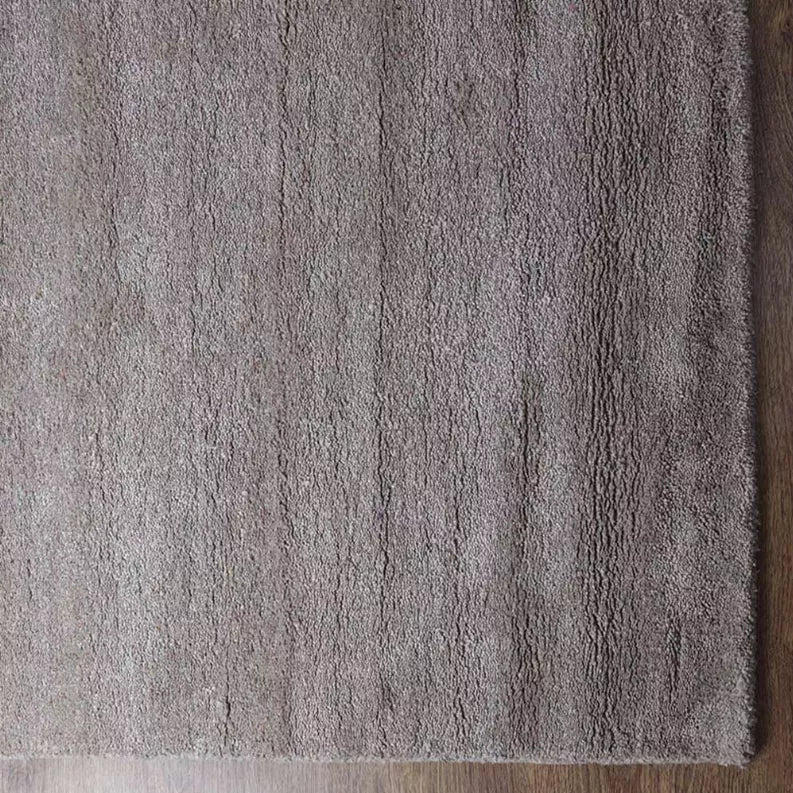 Rug corner detail in medium gray with tight pile texture and clean edge