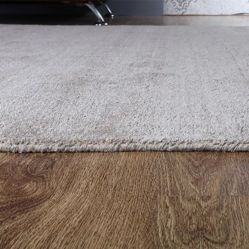 Medium gray square area rug with low pile and textured surface, trimmed edge