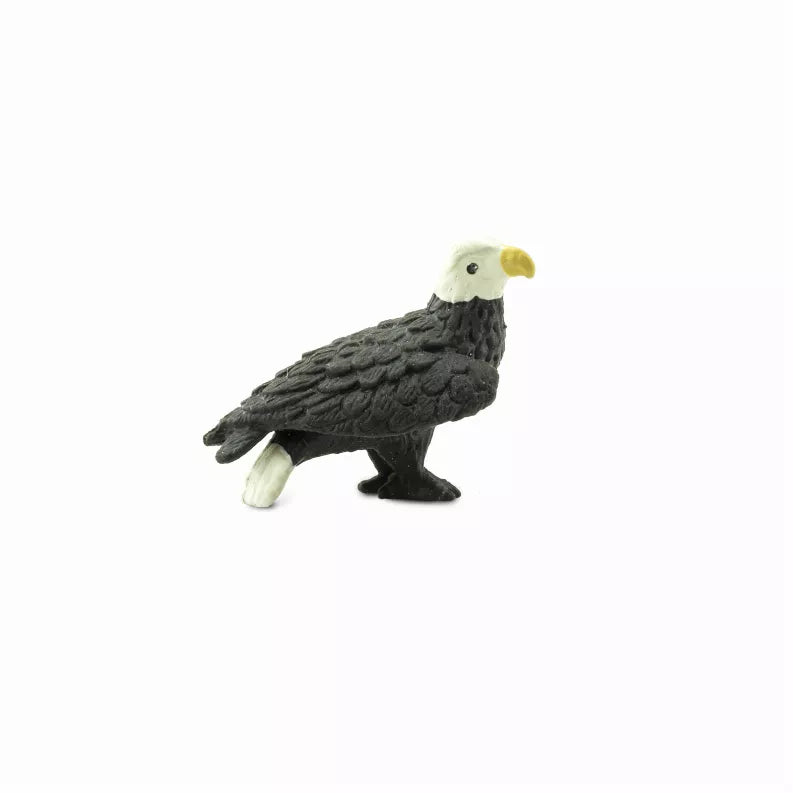 Bald eagle figurine toy with dark gray body, white head, and yellow beak