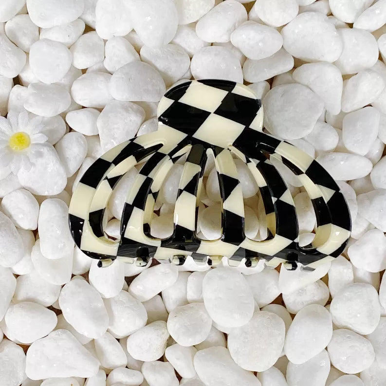 Checkerboard hair claw clip in black and cream with curved prongs
