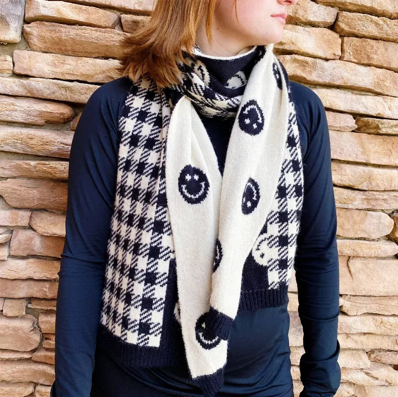 Navy-and-white checked scarf with smiley circles, draped at the neckline