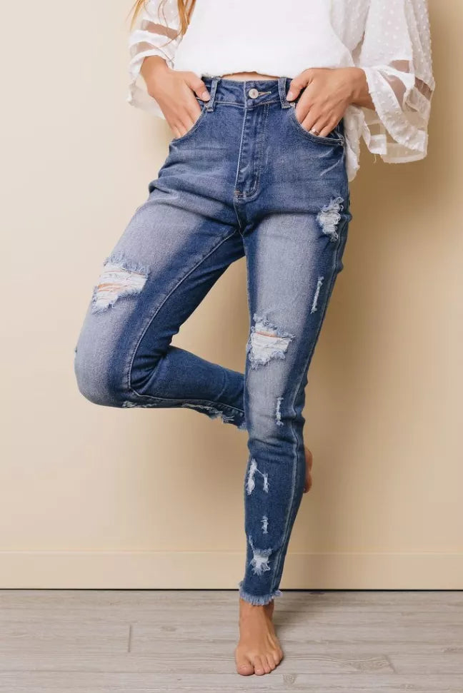 High-rise skinny jeans in light blue with distressed knees, rips at thighs, button closure