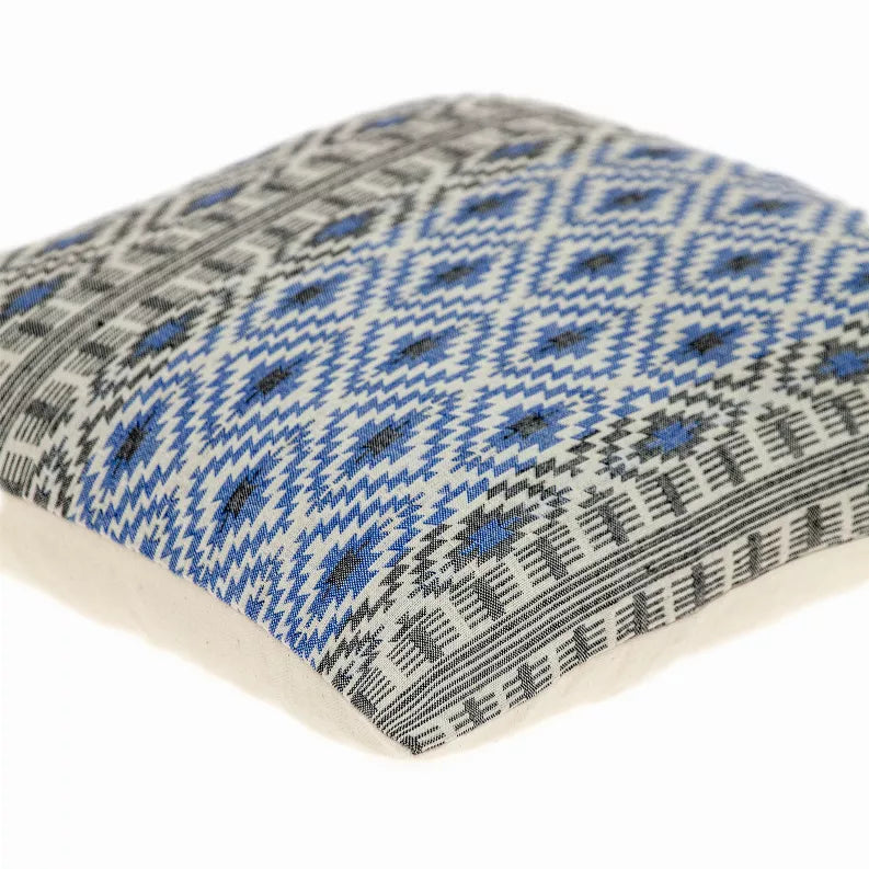 Throw pillow corner close-up with blue and gray geometric pattern on beige
